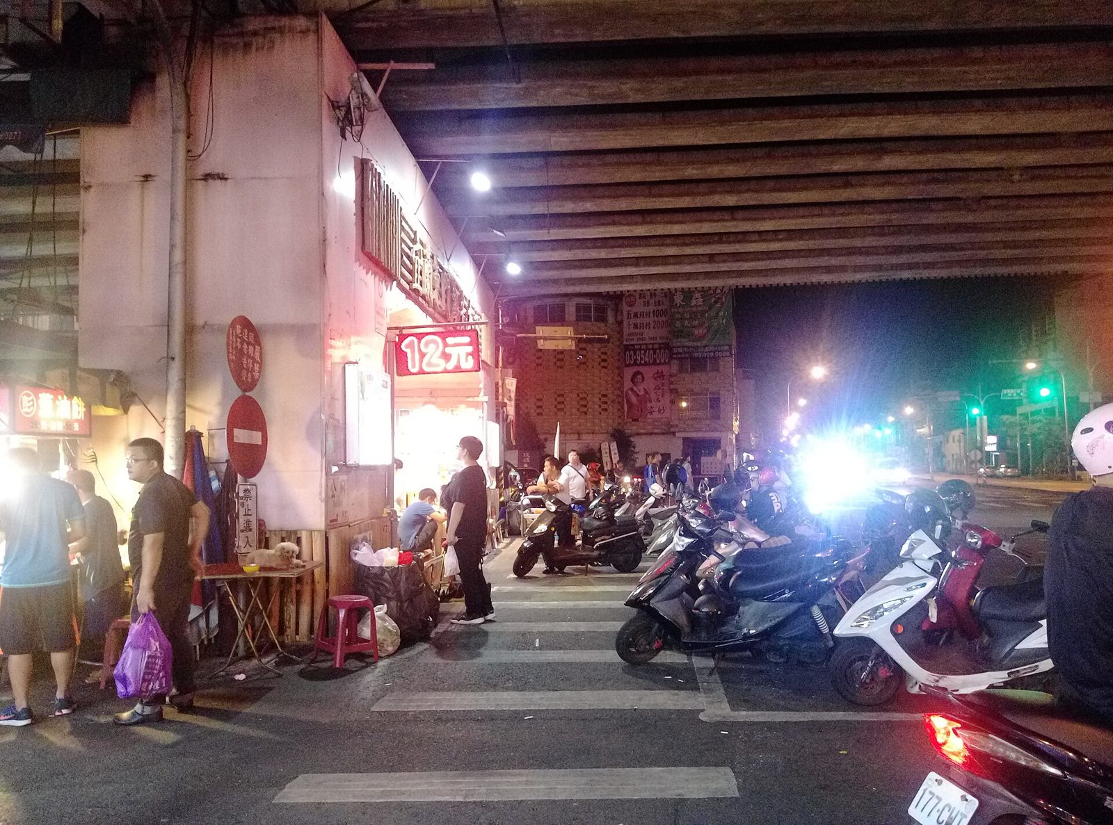 夜晚宜蘭東門夜市東港陸橋下的攤位和停放的機車