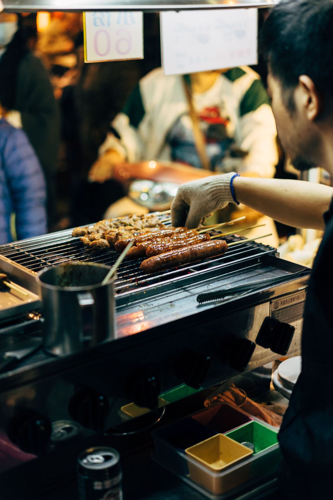 A vendor grilling sausages at a Taiwan night market